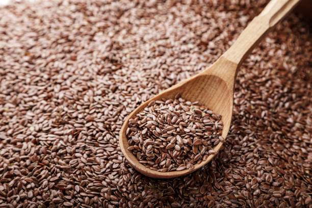 istock flax seeds scattered as a background and poured into a spoon. 1055222674