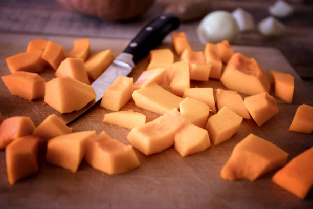 Pumpkin soup making, fresh raw ingredients close up. Sliced pumpkin
