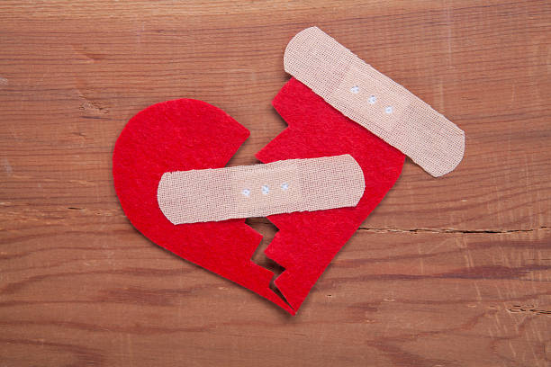 istock Tiny red heart sign isolated on wooden background. 1055225676