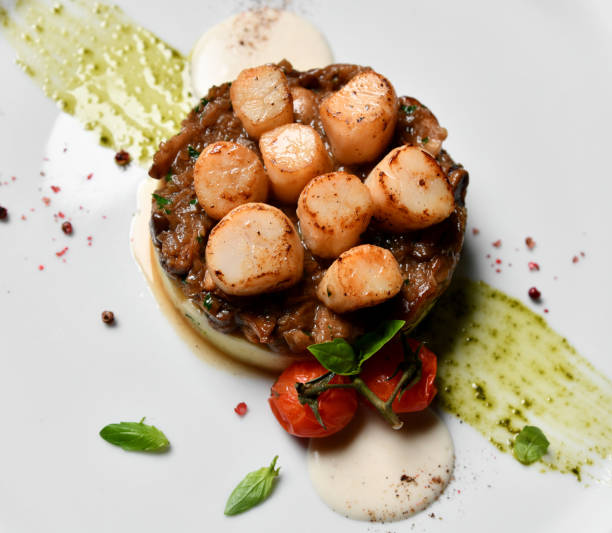 istock Plate with grilled scallops with butter lemon spicy sauce mashed potatoes and tomatoes top view 1055226344