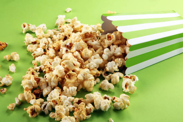 istock Cinema concept with popcorn in green white bag. 1055228188