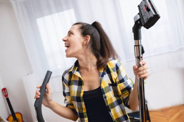 istock Woman singing and cleaning house 1055228606
