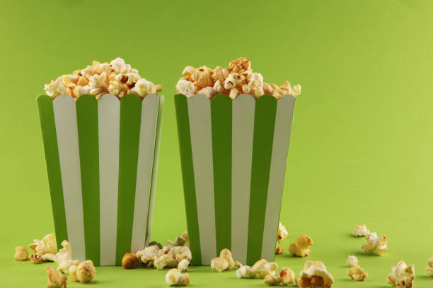istock Cinema concept with popcorn in green white bag. 1055228624
