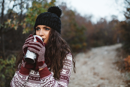 Young woman holding warm cup of tea