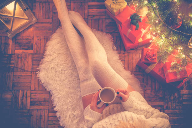 istock Young Woman Drinking Hot Coffee on Christmas Night 1055228740