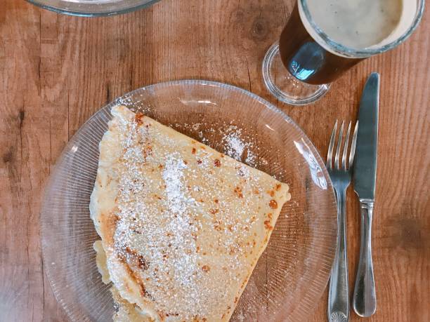 istock Breakfast with coffee and crepes served with sugar plate on the wood table texture 1055234340