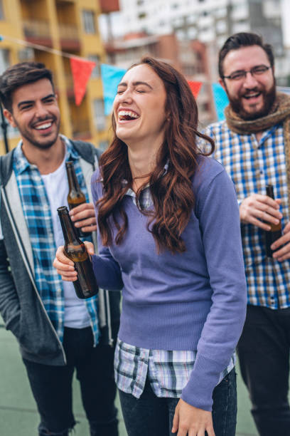 laughing woman at a roof party - after work beautiful people beer beer bottle imagens e fotografias de stock