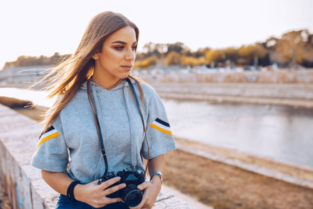 istock Beautiful young female with analog camera in action 1055249932