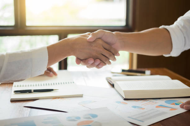 istock Cropped Image Of Business People Shaking Hands At Office 1055267014