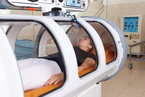 Girl patient lying in a hyperbaric chamber.