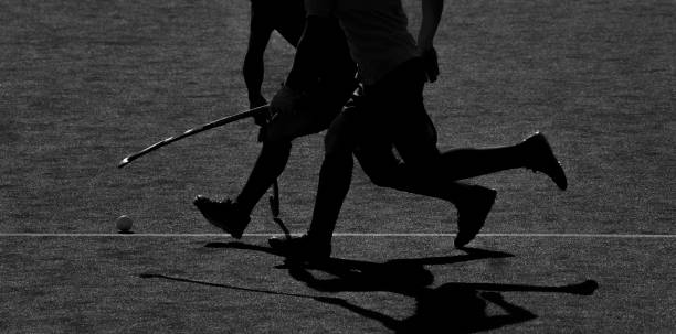 istock Low Section Of People Playing Hockey On Field 1055270050