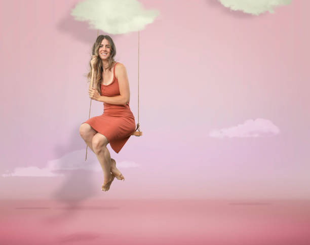 istock Woman hanging in a pink studio sky with clouds 1055270540