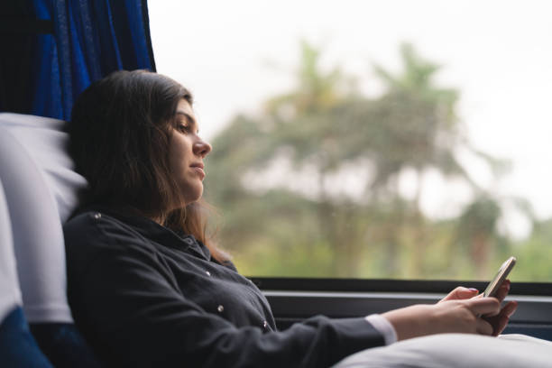 mujer utilizando el móvil en el autobús - bus coach bus travel red fotografías e imágenes de stock