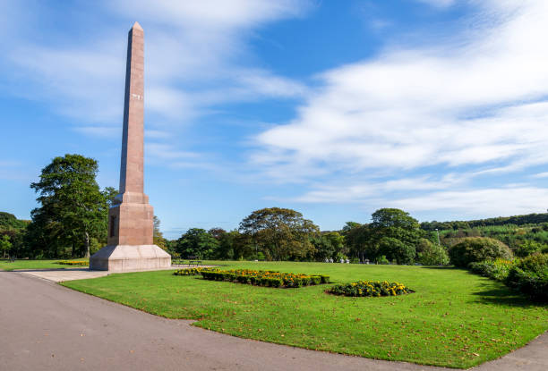 istock Magnificent McGrigor Obelisk with flower beds in front on a blue sky background, Duthie Park, Aberdeen, Scotland 1055276882