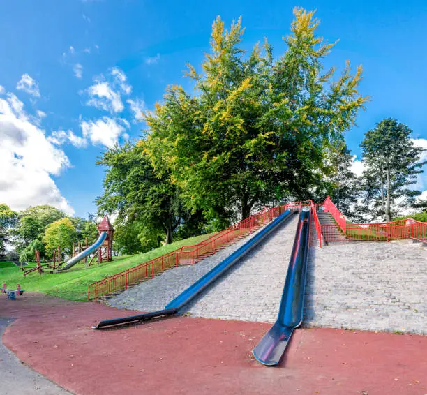 Photo of Large metal slides on top of a small hill at the entrance to Duthie Park, Aberdeen, Scotland