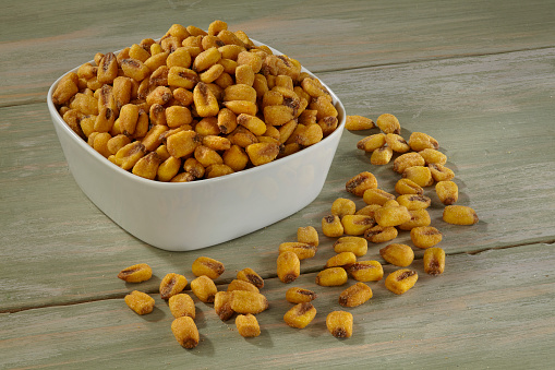 Corn Nuts in white bowl on wooden background