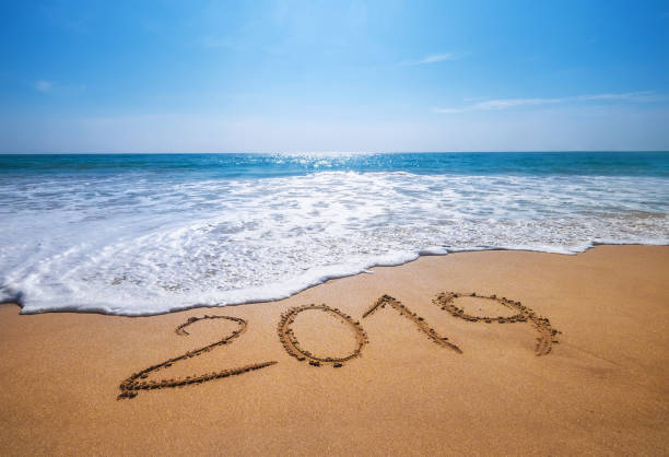 Happy New Year 2019 is coming concept sandy tropical ocean beach lettering concept image and Happy New Year 2019 is coming concept sandy tropical ocean beach lettering concept image and new year's eve 2019 stock pictures, royalty-free photos & images