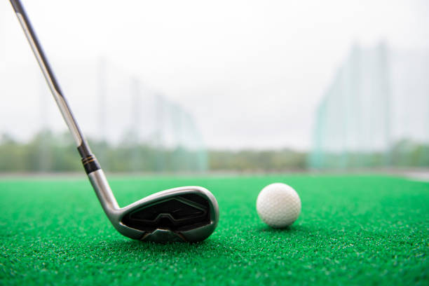 Golf equipment at a driving range Golf club and balls on a synthetic grass mat at a practice range. drive ball sports photos stock pictures, royalty-free photos & images