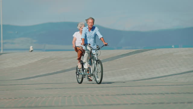 Full length of senior couple riding tandem bicycle