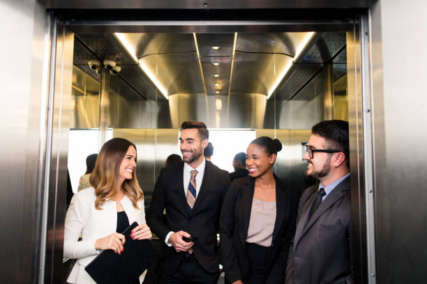 istock Group of latin business executives laughing in elevator 1055292134