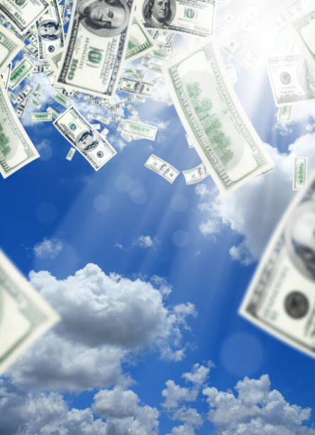 istock blurry flying one hundred dollar bills in sunny sky 1055293252