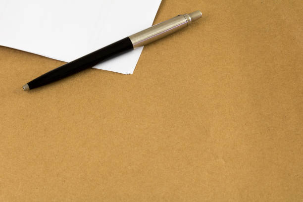 istock Pen and paper. Brown envelope background. 1055303720