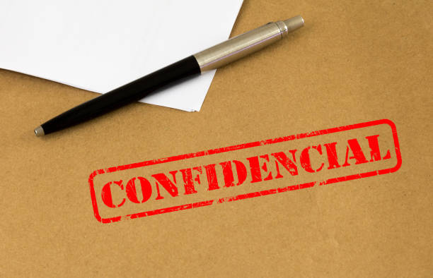 istock Pen on brown paper envelope with confidential stamped. (Translation portuguese: 