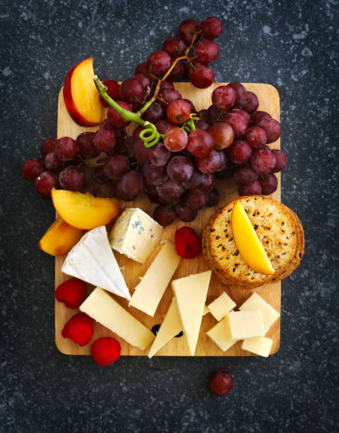 istock Cheese, crackers and fruits on wooden background 1055303788