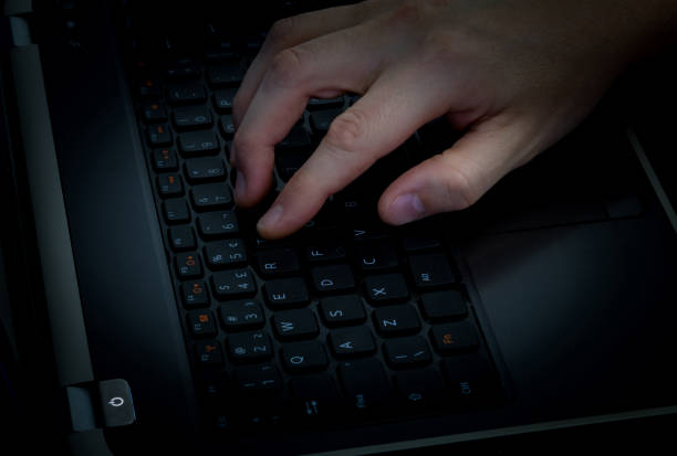 istock Close-up hand on keyboard in dark room. 1055303834