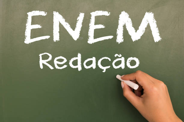 istock Female hand writing with chalk on empty green chalkboard. (translation portuguese: ENEM - National High School Exam Brazil - writing) 1055304196