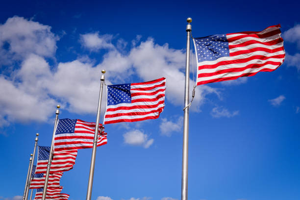 американские флаги подряд на мачте у памятника вашингтону в вашингтоне - washington dc monument sky cloudscape стоковые фото и изображения