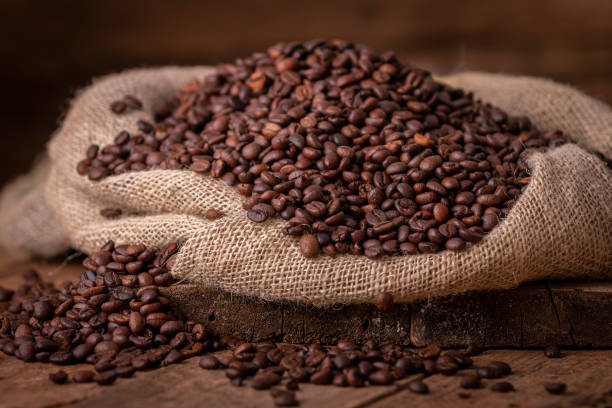Sack of spilled roasted coffee beans stock photo