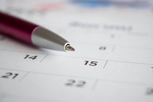 istock Calendar page with pen point at 15th date 1055312312