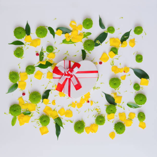 istock Gift in shape of heart with pattern from petals. 1055325448