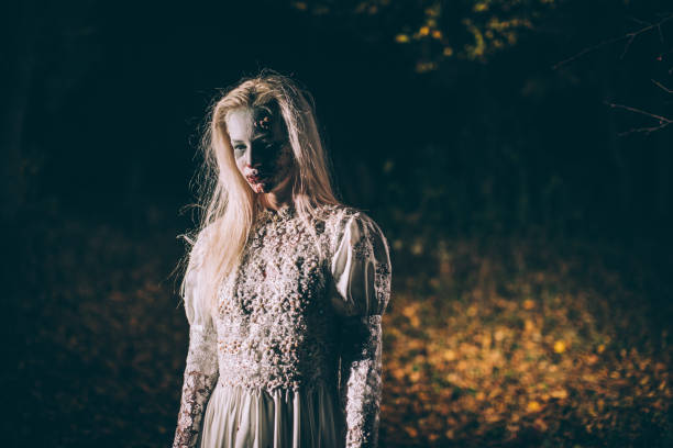 istock Woman dressed as witch in dark forest 1055334422