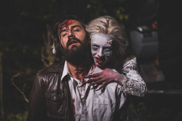 Witch attacked a man at night Man and woman, she masked herself in a scary witch for halloween, attacking a man. male vampire biting his victim stock pictures, royalty-free photos & images