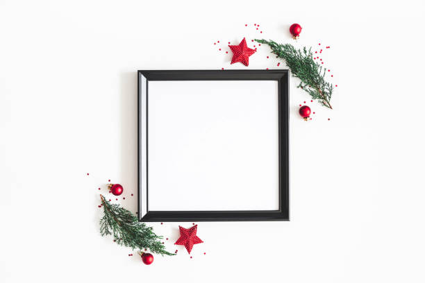 istock Christmas composition. Photo frame, red decorations, fir tree branches on white background. Christmas, winter, new year concept. Flat lay, top view, copy space 1055345098