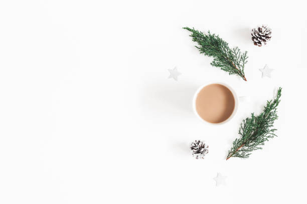 istock Christmas composition. Cup of coffee, fir tree branches, pine cones on white background. Flat lay, top view, copy space 1055345478