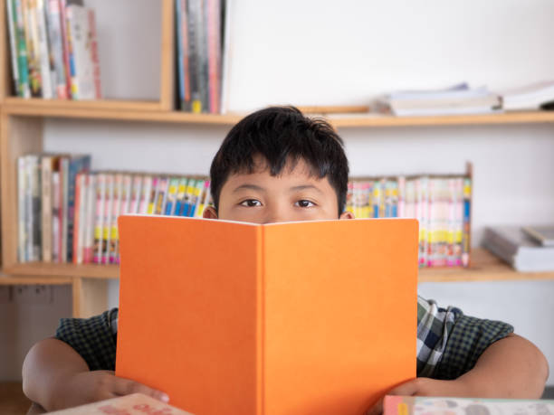 istock Cute asian children reading a book at home. education concept 1055349802
