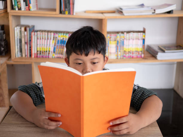 istock Cute asian children reading a book at home. education concept 1055349898