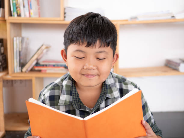 istock Cute asian children reading a book at home. education concept 1055349980