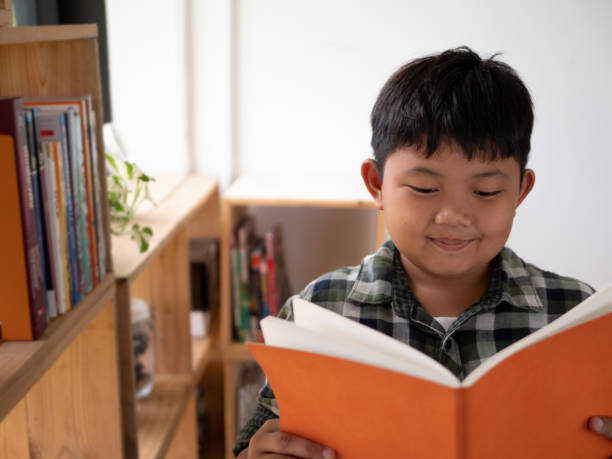 istock Cute asian children reading a book at home. education concept 1055349996