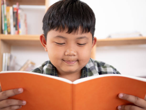 istock Cute asian children reading a book at home. education concept 1055350014