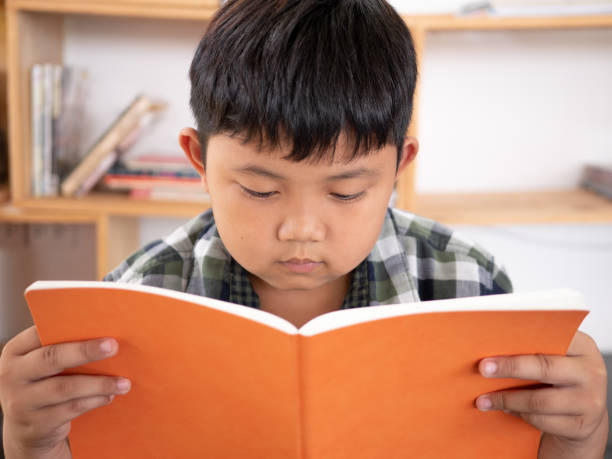 istock Cute asian children reading a book at home. education concept 1055350022
