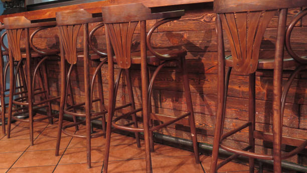 istock Row of vacant wooden bar stools 1055356318