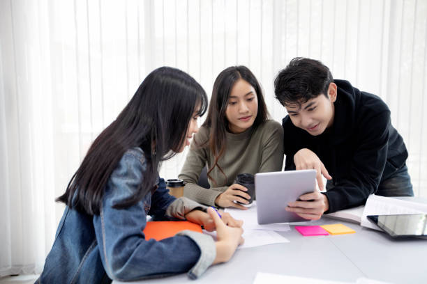 Group Students Smile and have fun and using tablet It also helps to share ideas in the work and project. And also review the book before the exam