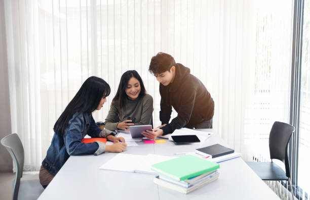 istock Group Students Smile and have fun and using tablet It also helps to share ideas in the work and project. And also review the book before the exam 1055370920