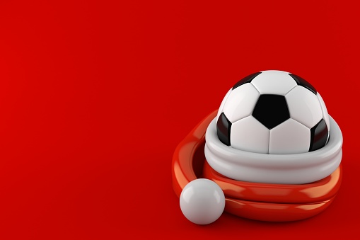 Soccer ball inside santa hat isolated on red background. 3d illustration