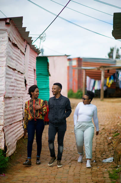 istock Three Friends Walking together in Township laughing 1055385860