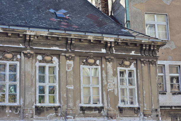Weathered old apartment houses with tall multi pane windows and pain peeling off from exterior walls.